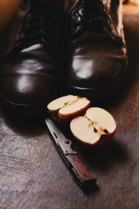 sliced apple fruit near black boots