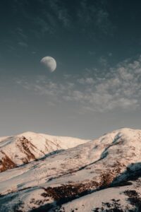 snow capped mountains under moon
