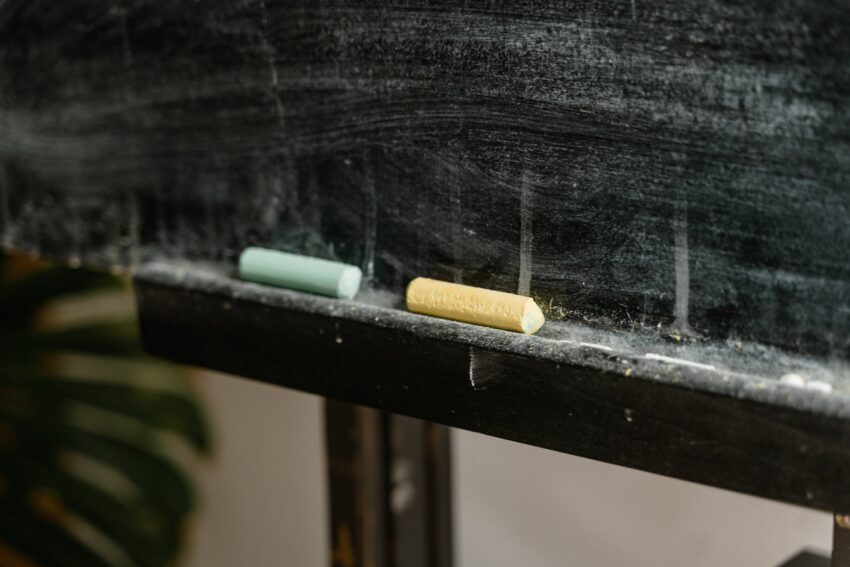 close up photo of two chalk near the blackboard